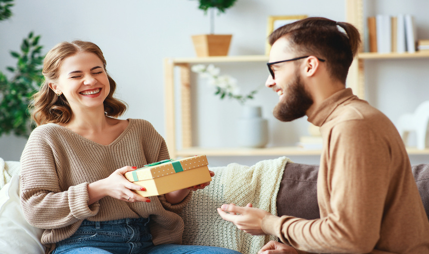  A woman enjoying a Christmas present from a man.